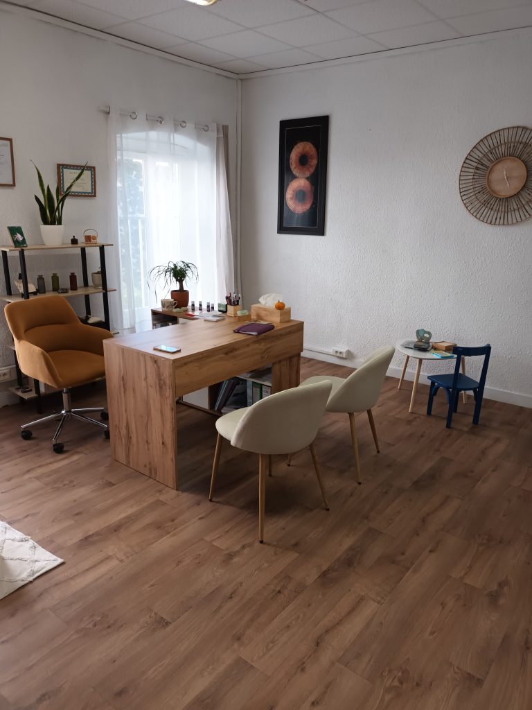 Cabinet de sophrologie de Montbrison : bureau en bois, chaises et étagère de plantes