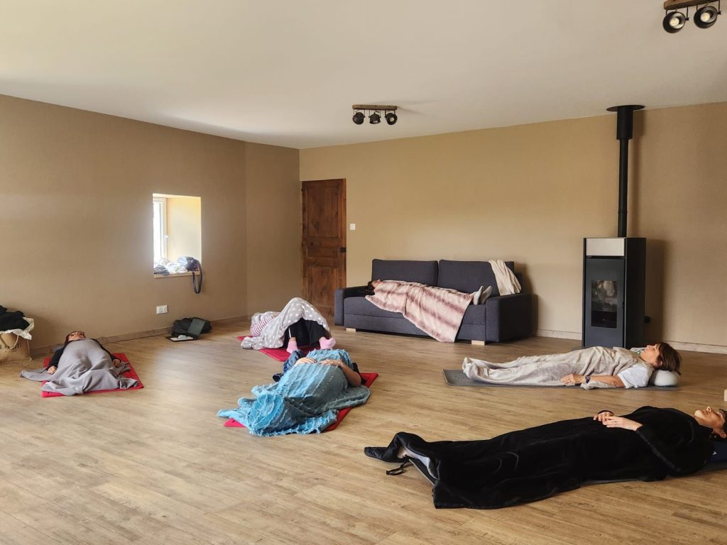 Groupe de participants allongés sur des tapis pendant une séance de sophrologie collective à Saint-Anthème
